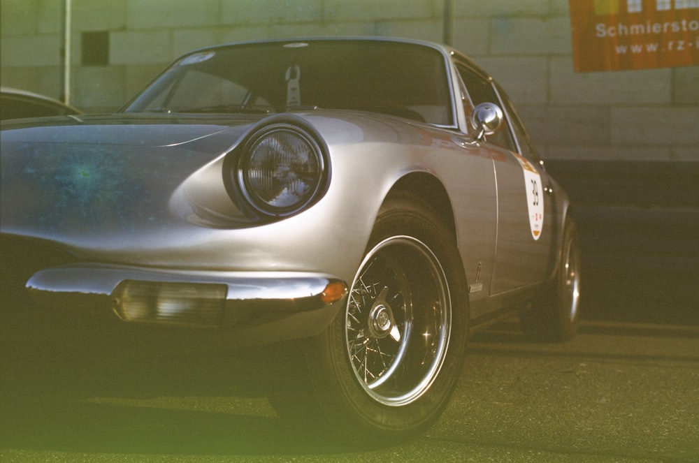 a silver sports car parked in front of a building