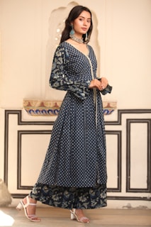 a woman in a long dress standing in a room