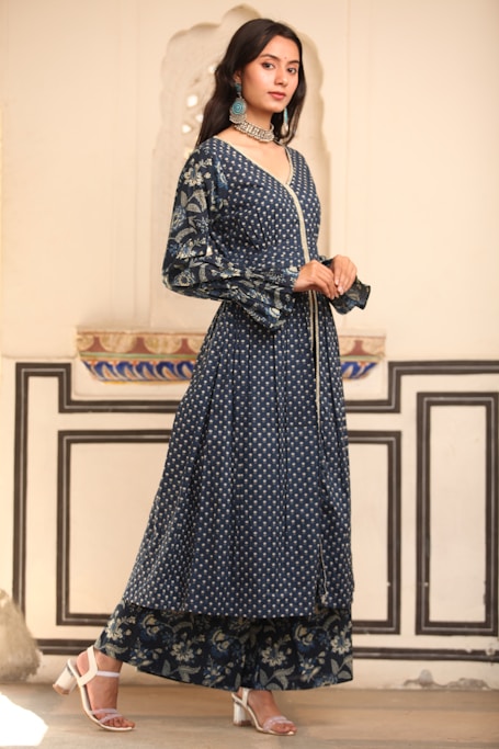 a woman in a long dress standing in a room