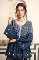 A royal blue anarkali suit adorned with delicate silver threadwork displayed against a vintage backdrop.