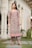 A happy woman wearing a stylish Pakistani suit in a bright outdoor setting.