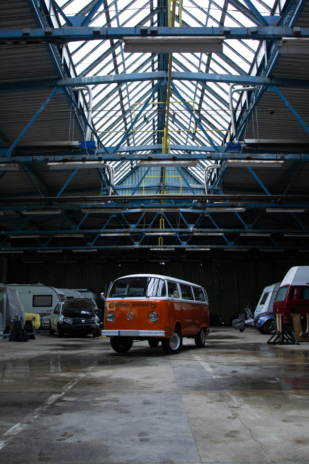 Un furgone arancione e bianco parcheggiato in un garage