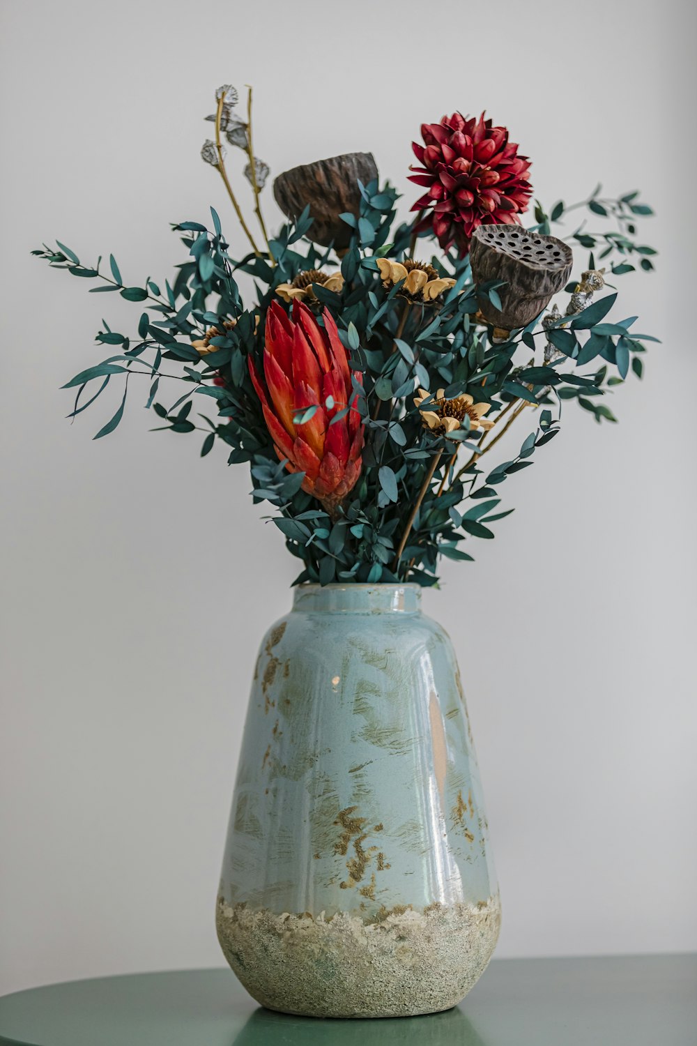 a vase filled with lots of flowers on top of a table