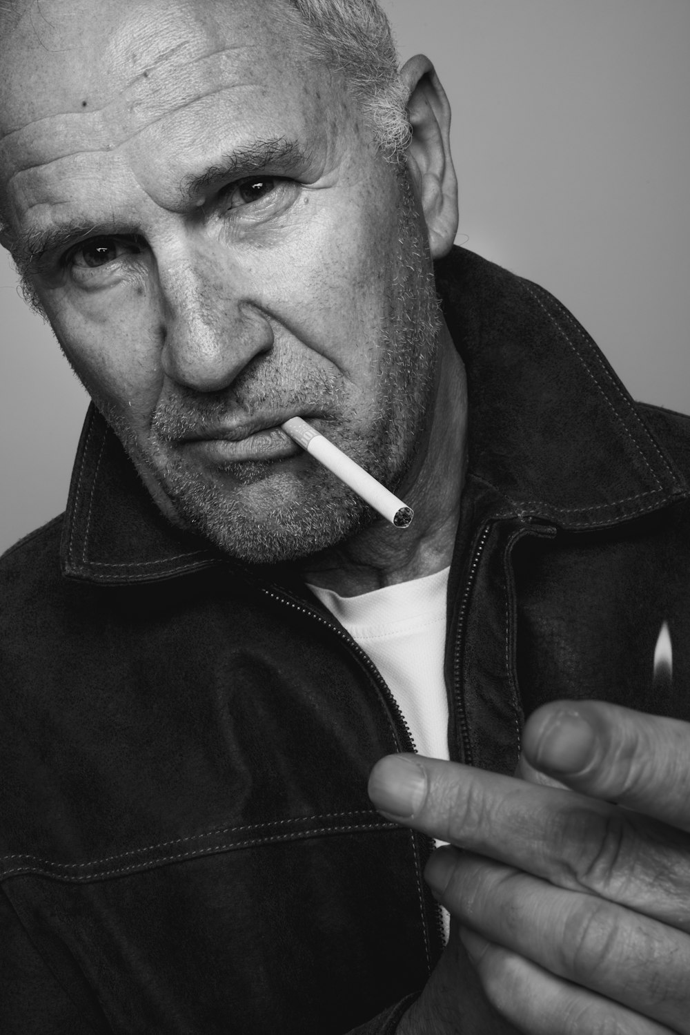 a black and white photo of a man smoking a cigarette