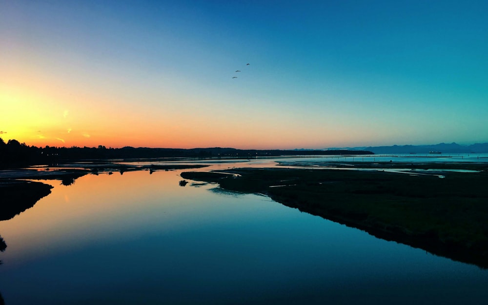 the sun is setting over a body of water