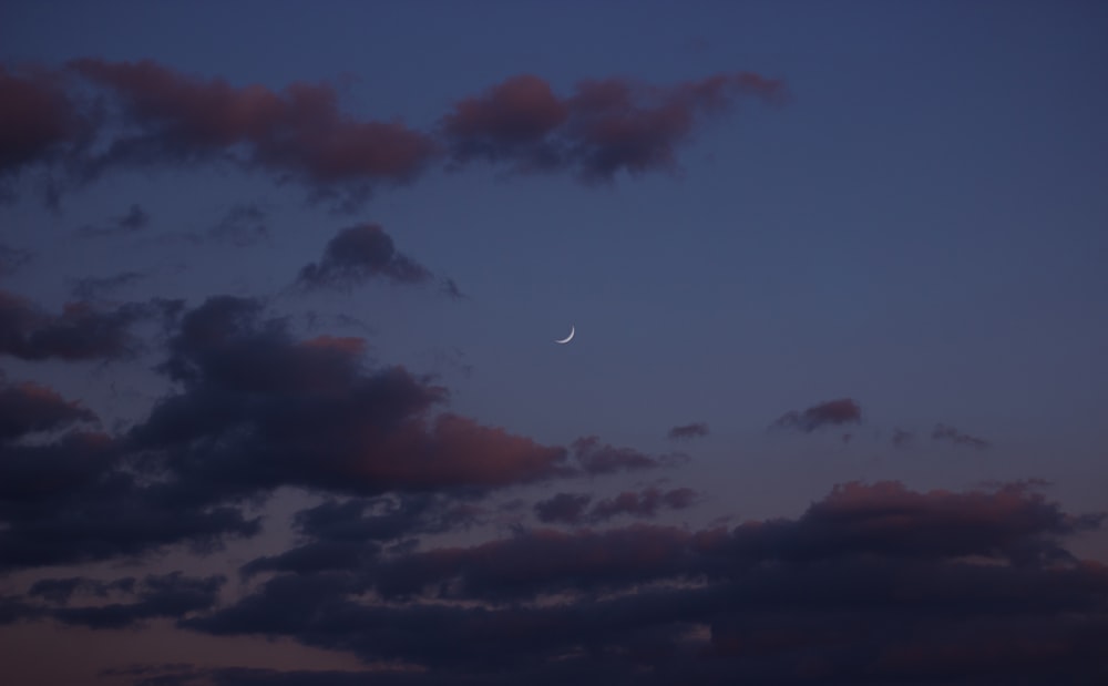 the moon is seen through the clouds in the night sky