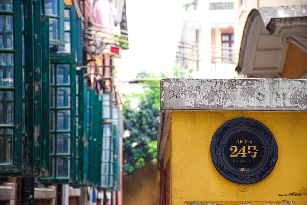 a yellow building with a black clock on it