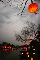 A serene scene of a riverbank during an Indian festival with floating lamps.