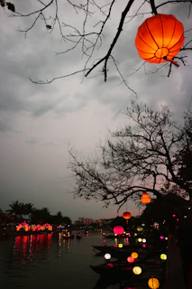 A serene scene of a riverbank during an Indian festival with floating lamps.