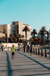 a man riding a skateboard down a sidewalk next to palm trees