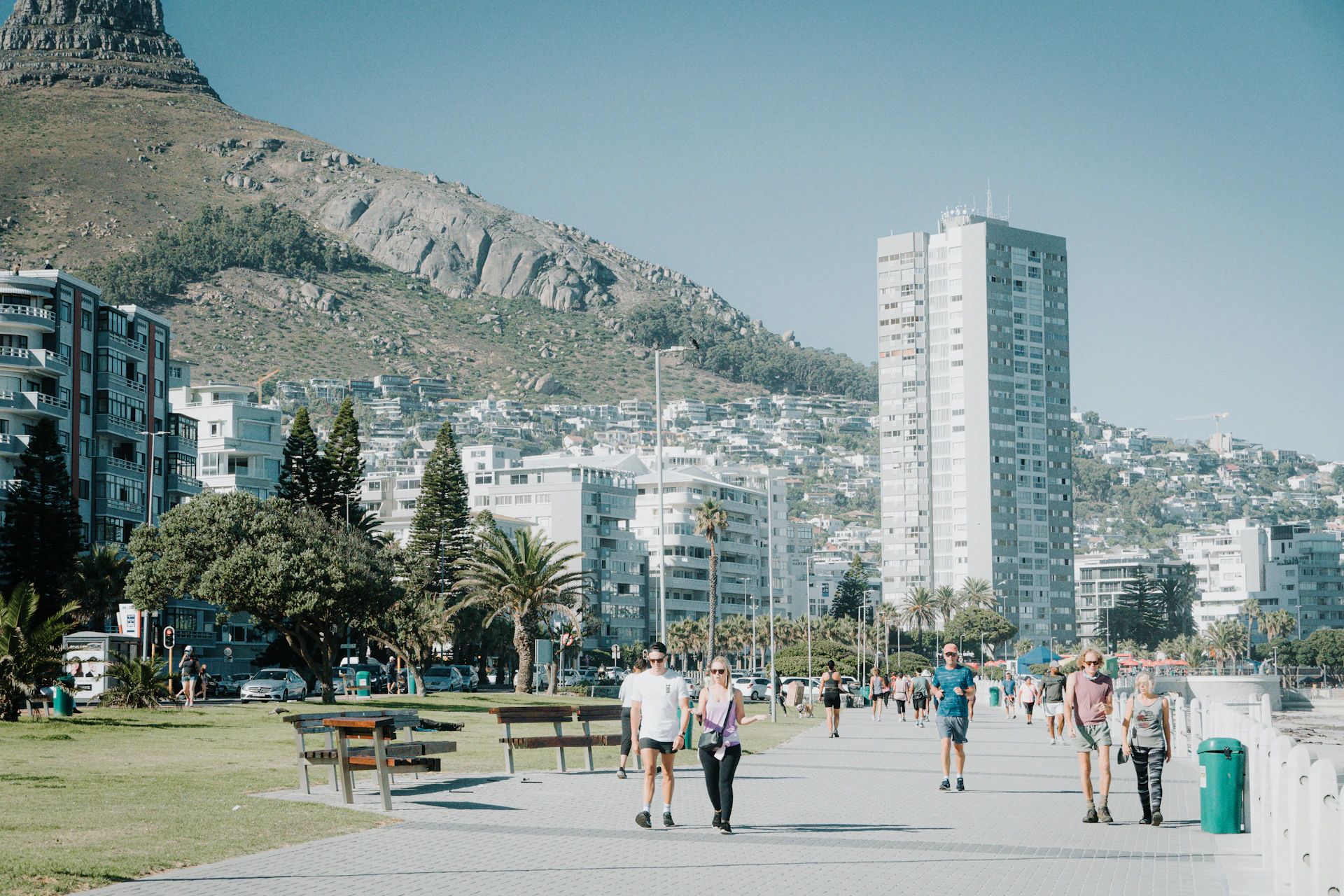 a group of people walking down a street next to tall buildings