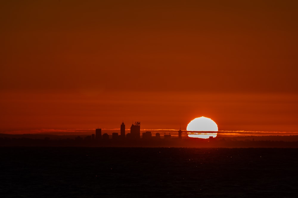 the sun is setting over a city skyline