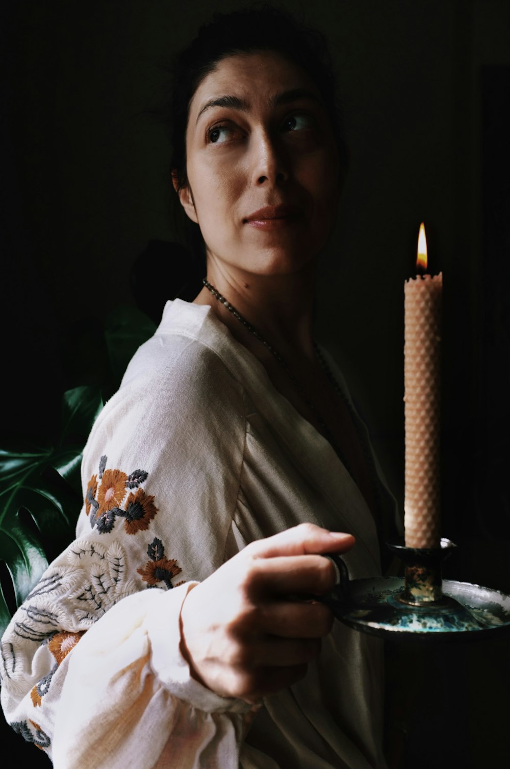 a woman holding a plate with a candle on it