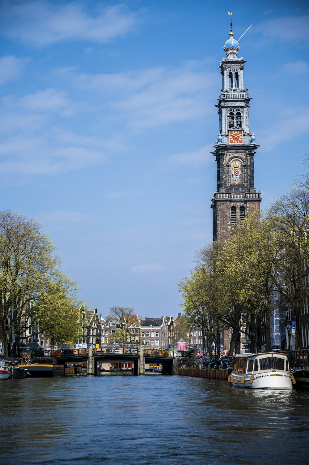 Ein Fluss mit Booten und einem Uhrturm im Hintergrund