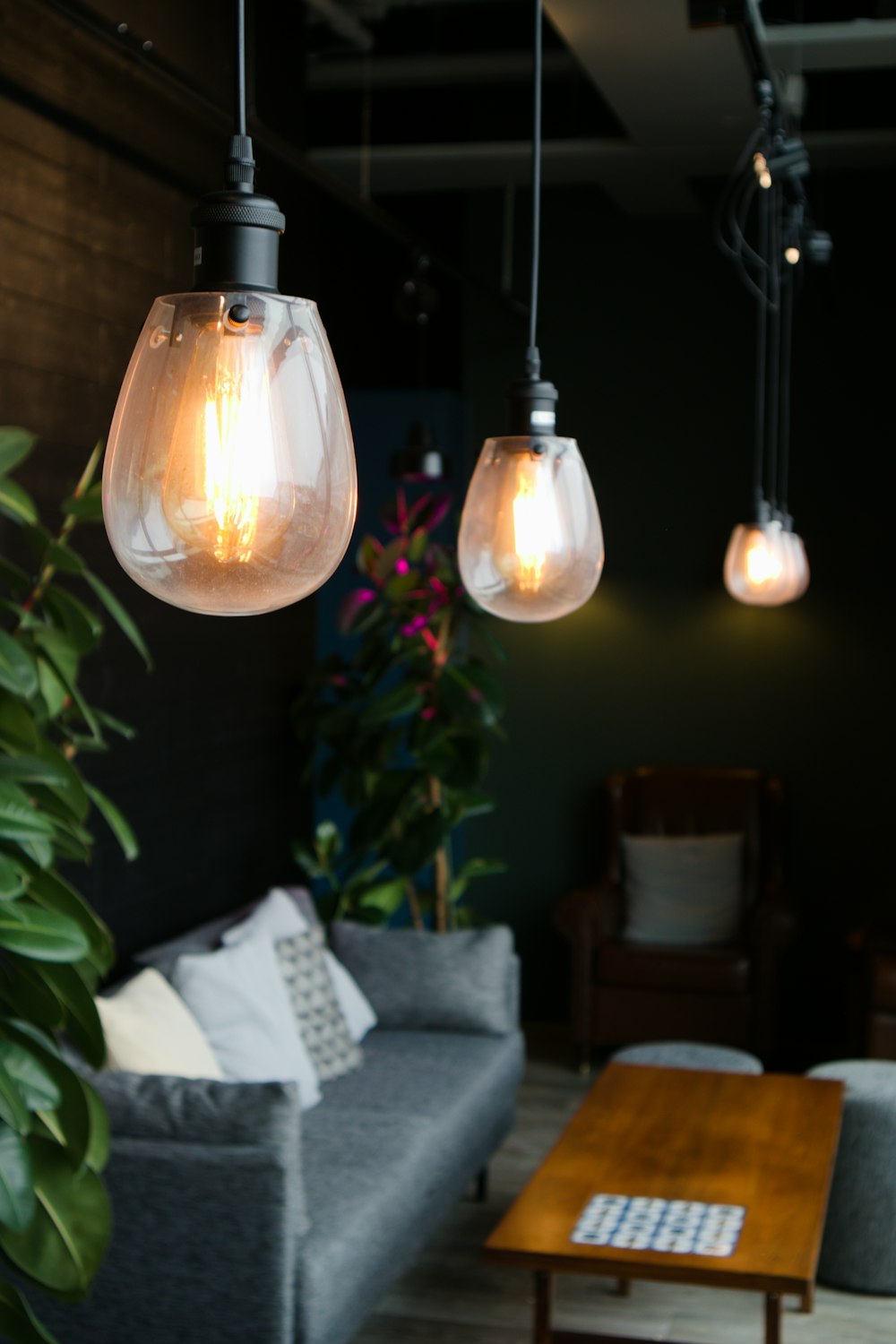 a living room filled with furniture and hanging lights