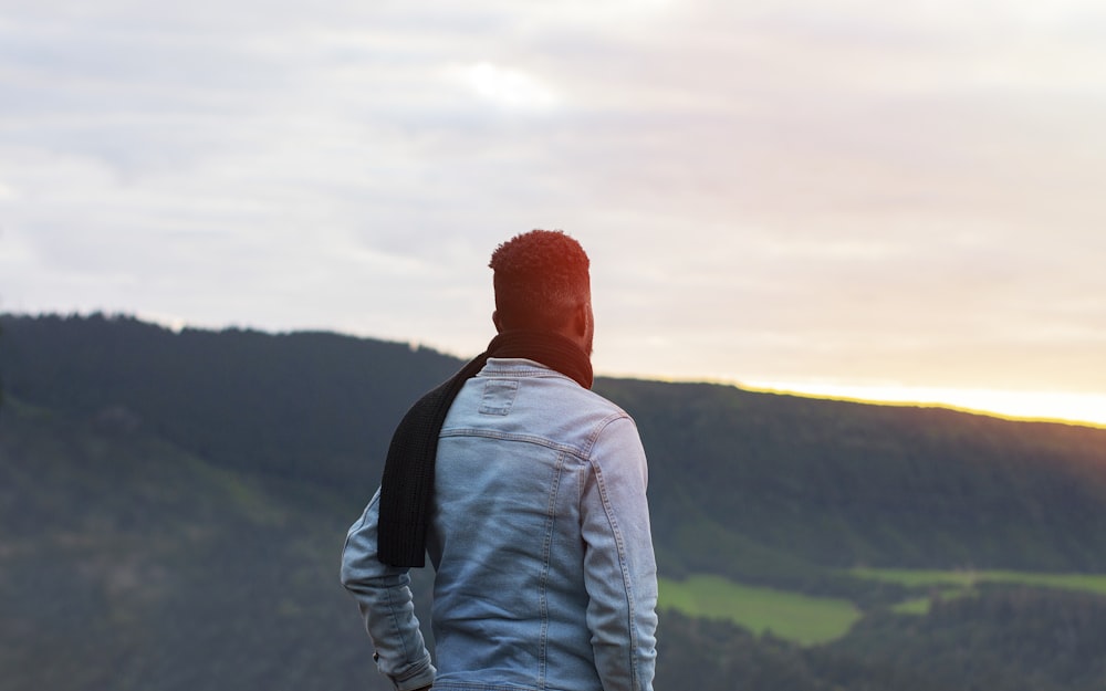 a man standing on top of a lush green hillside