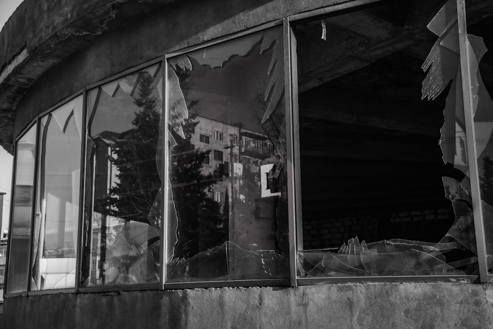 a black and white photo of a broken window