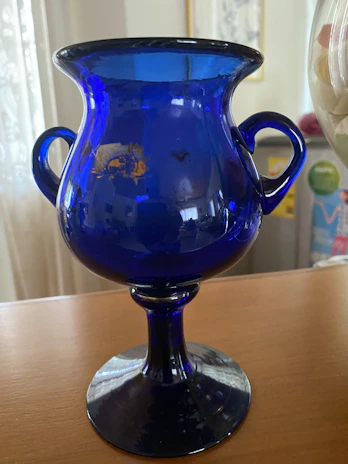 A delicate glass vase with swirling blue and green hues catching the light.