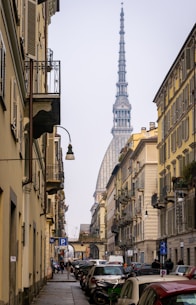 a street lined with parked cars and tall buildings
