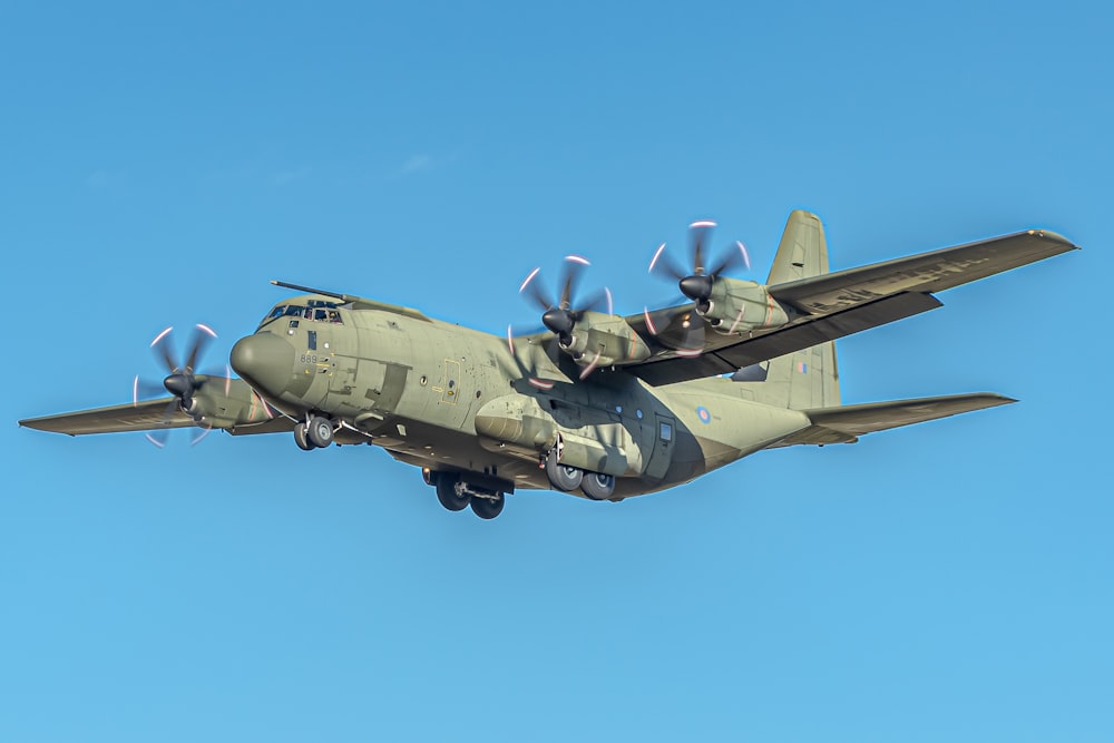 Ein großes Militärflugzeug fliegt durch einen blauen Himmel