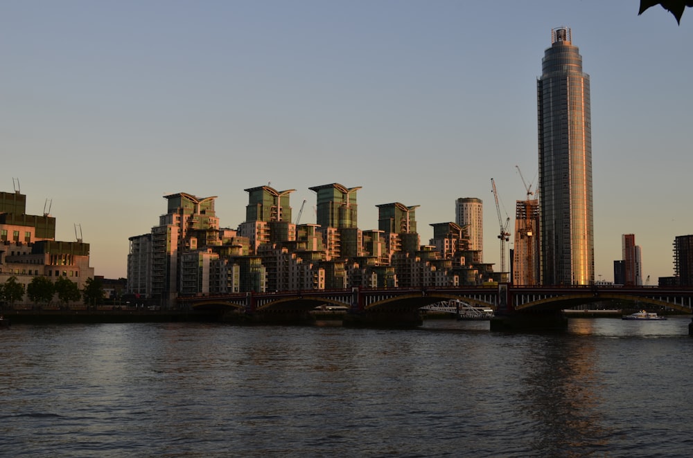 a city skyline with a bridge over a body of water