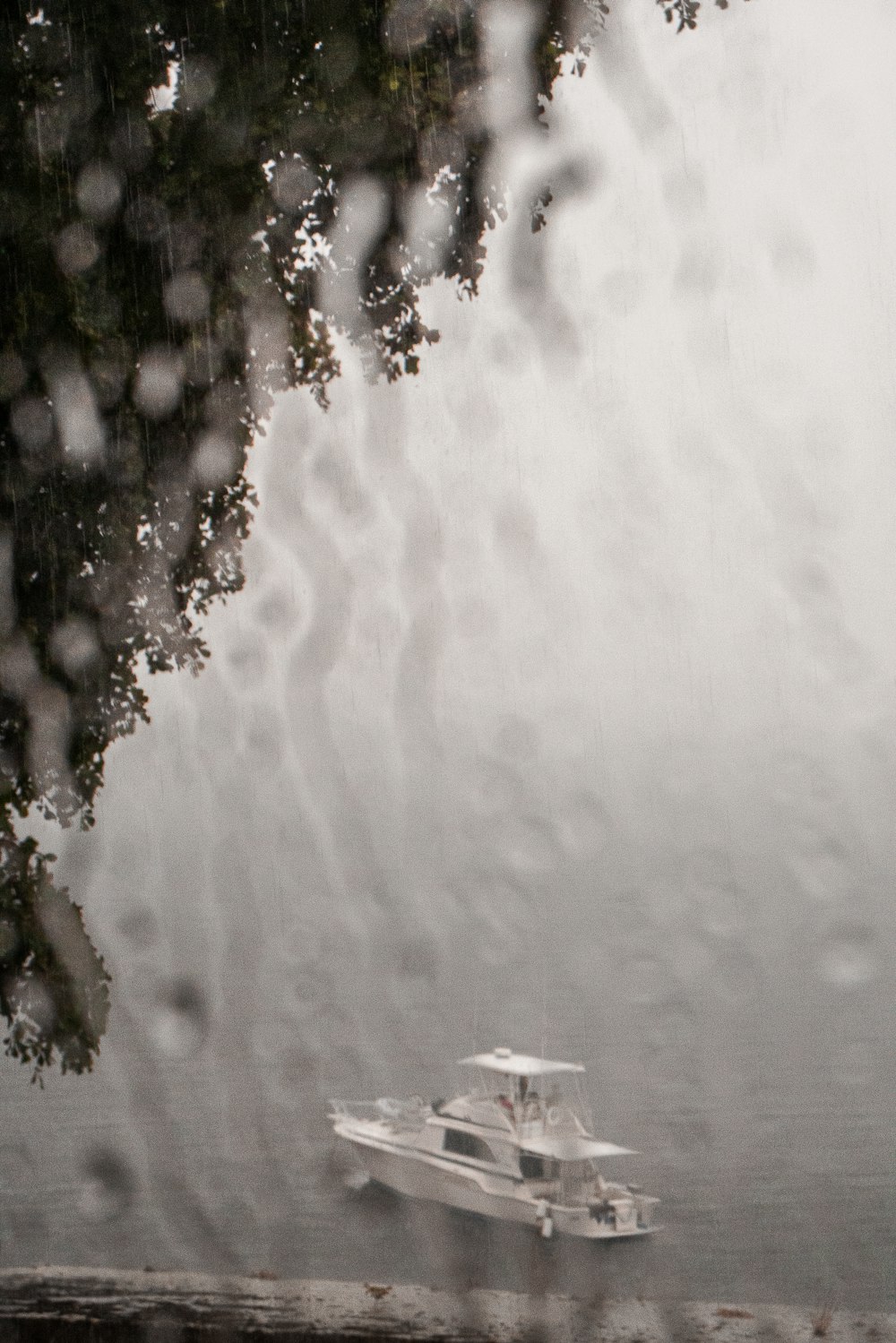 a boat is seen through a window on a rainy day