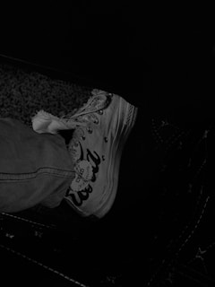 Side view of a casual sneaker worn by a person walking on a city street.