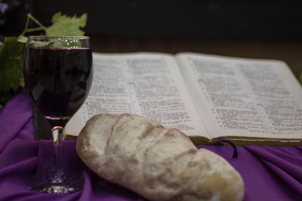 a glass of wine and a book on a table