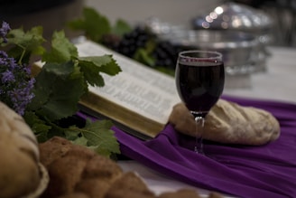 a glass of wine and a book on a table