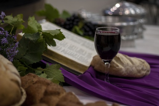 a glass of wine and a book on a table