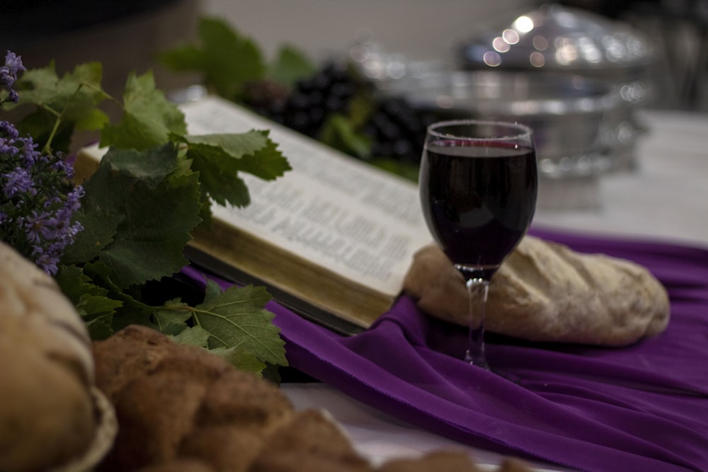 a glass of wine and a book on a table