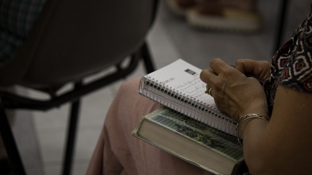 a woman sitting in a chair holding a book