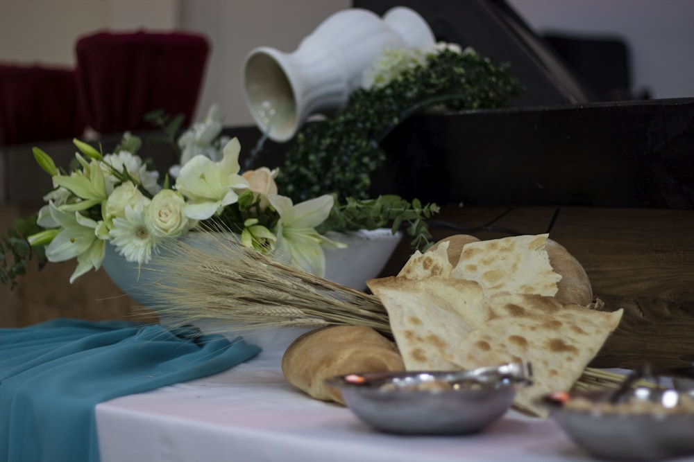 a table topped with bowls of food and a vase filled with flowers