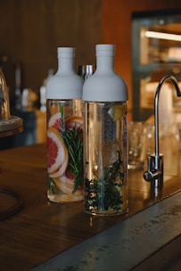 Refreshing healthy drinks in glass bottles with fresh fruit and herbs around.