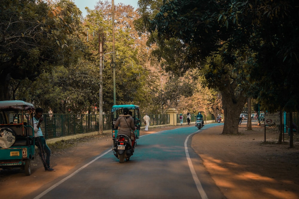 a man riding a motorcycle down a street next to a motorcycle