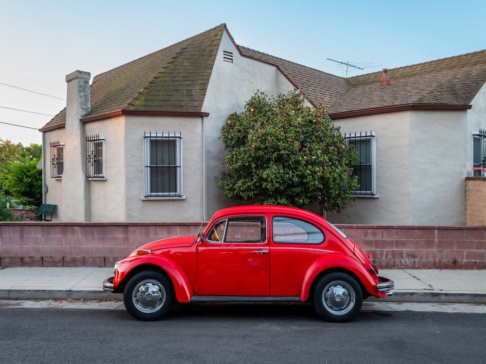 a red car parked in front of a house