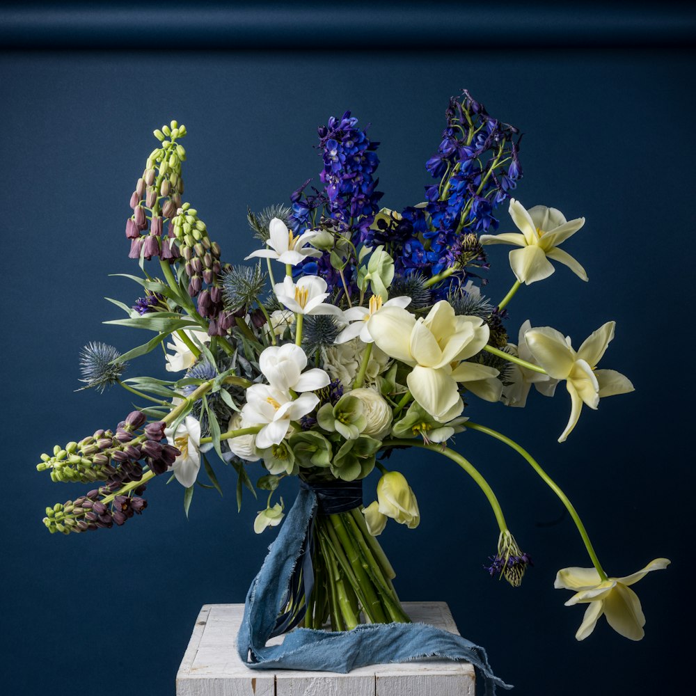 a bouquet of flowers sitting on top of a wooden block