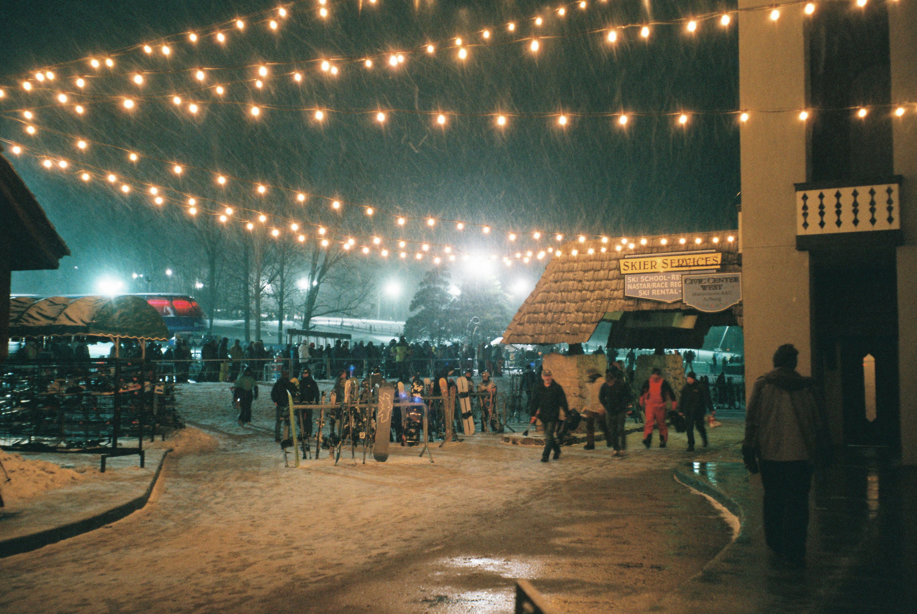 a crowd of people walking around a snow covered street