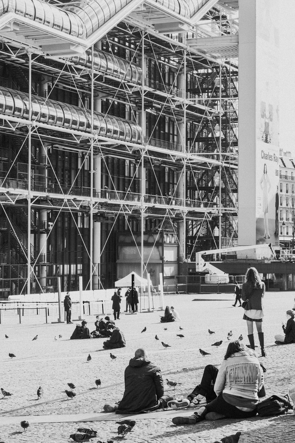 a group of people sitting on the ground in front of a building