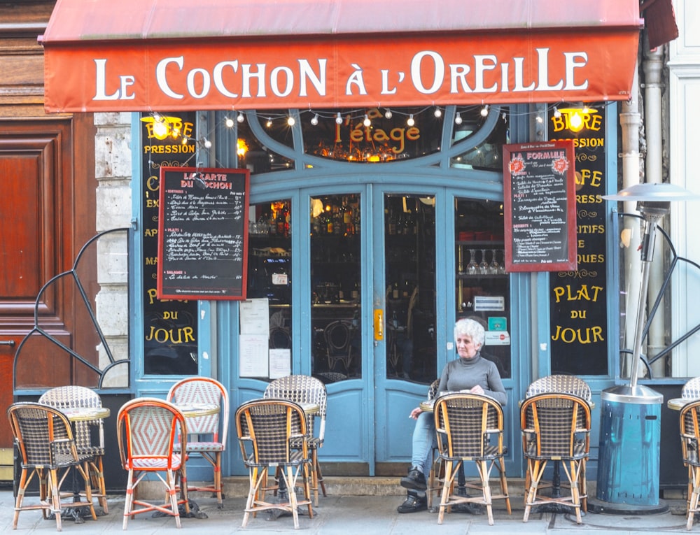 a man sitting at a table in front of a restaurant