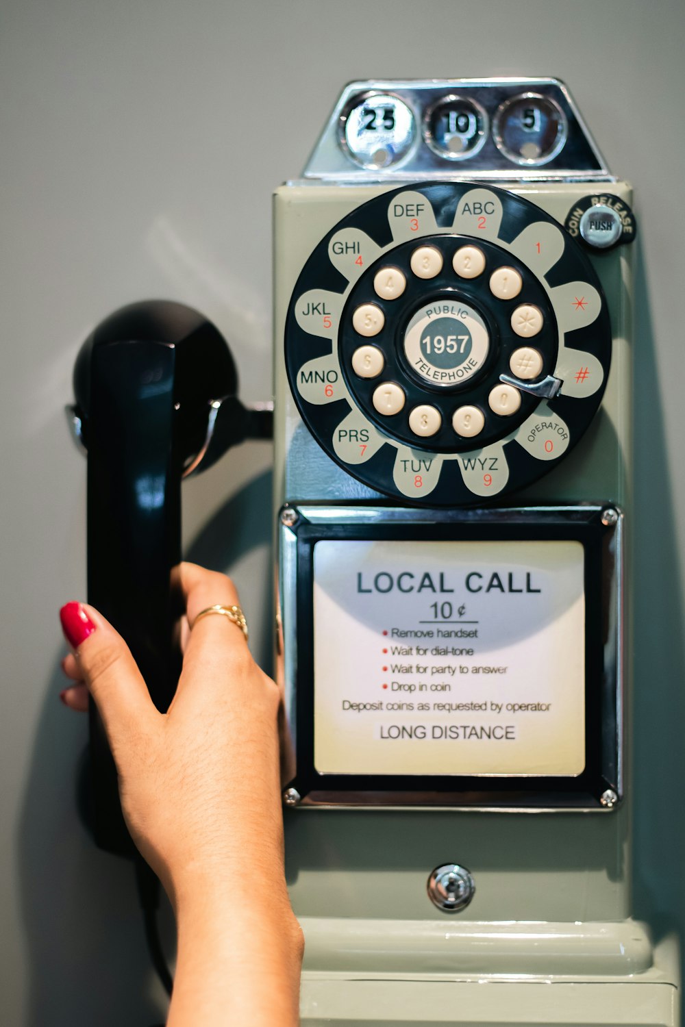 a woman's hand is pressing a button on a telephone