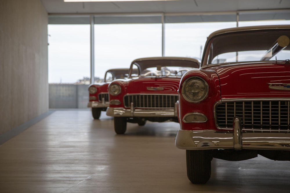 a row of classic cars parked in a garage