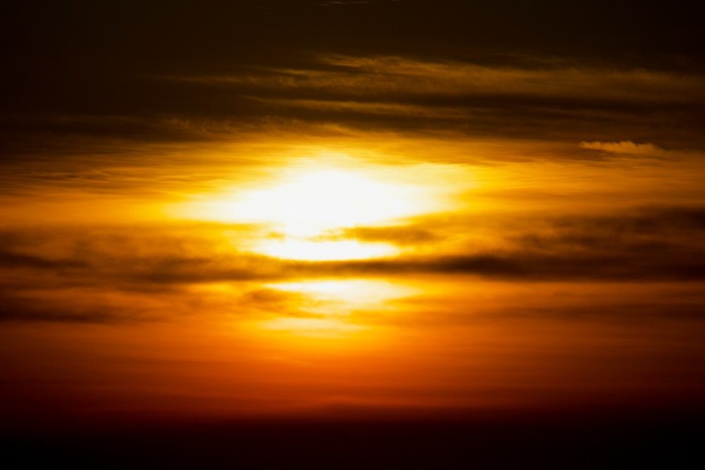 a plane flying in the sky at sunset