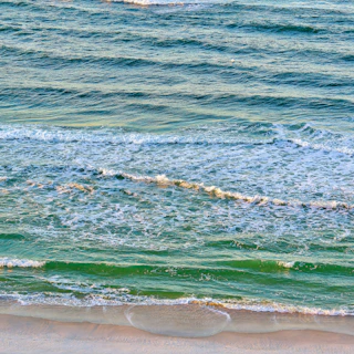 a person riding a surfboard on a wave covered beach