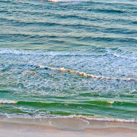 a person riding a surfboard on a wave covered beach