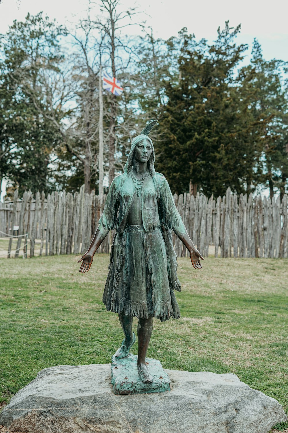 a statue of a woman standing on a rock