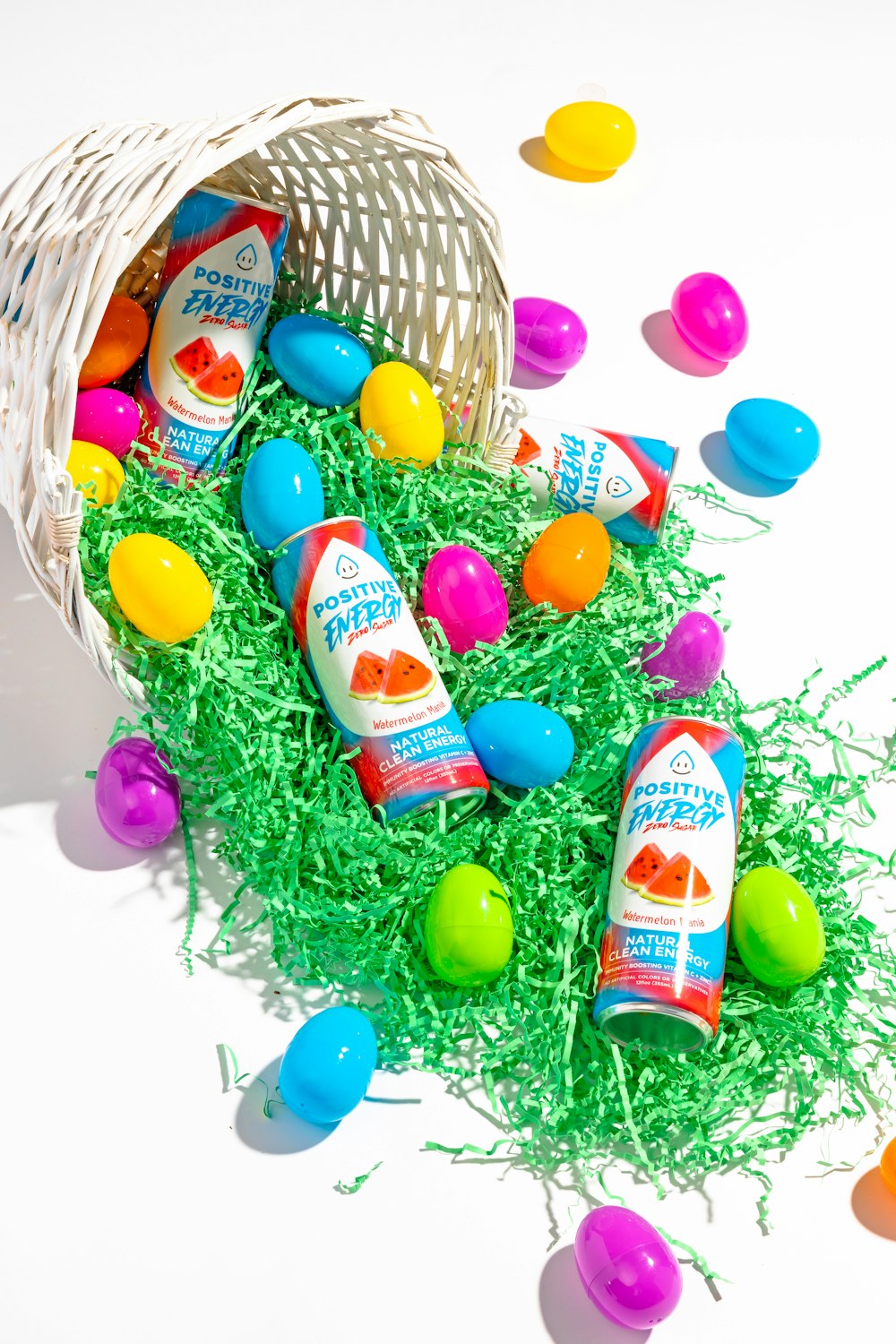 a basket filled with eggs and candy on top of grass