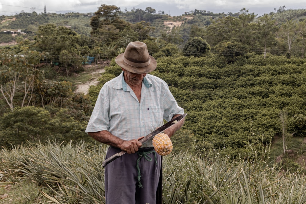 a man standing in a field with a hat on