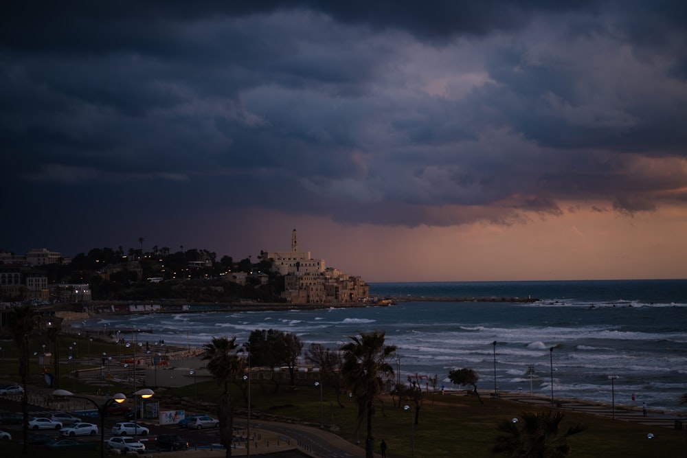 a storm rolls in over the ocean with a city in the distance