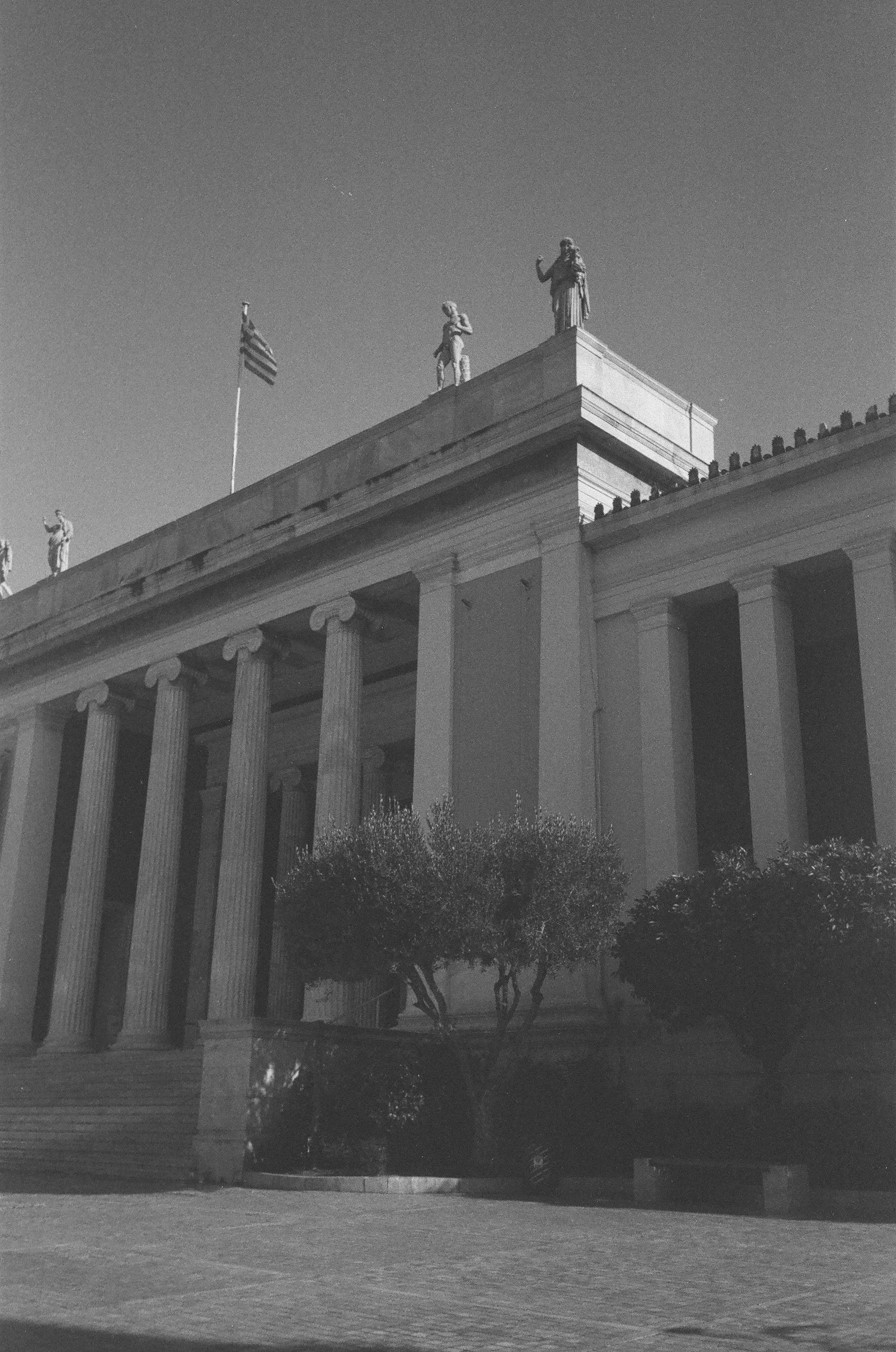 Government building with classical columns in daylight, clear blue sky, formal institutional architecture